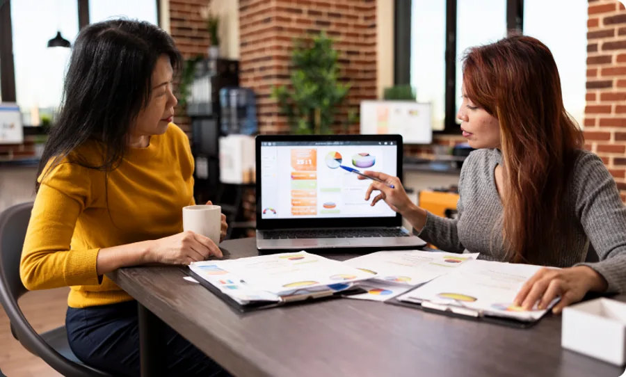 Two colleagues analysing conversion data on a laptop