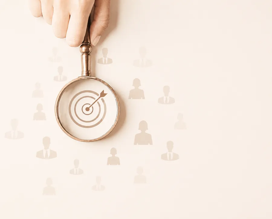 A magnifier held over a target surrounded by account icons