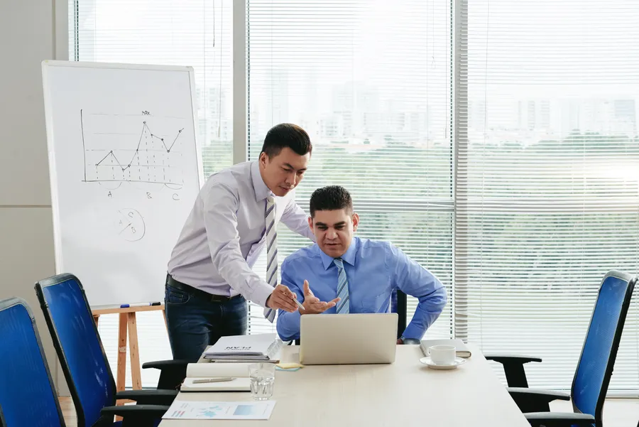 Two colleagues reviewing a growth plan at a whiteboard