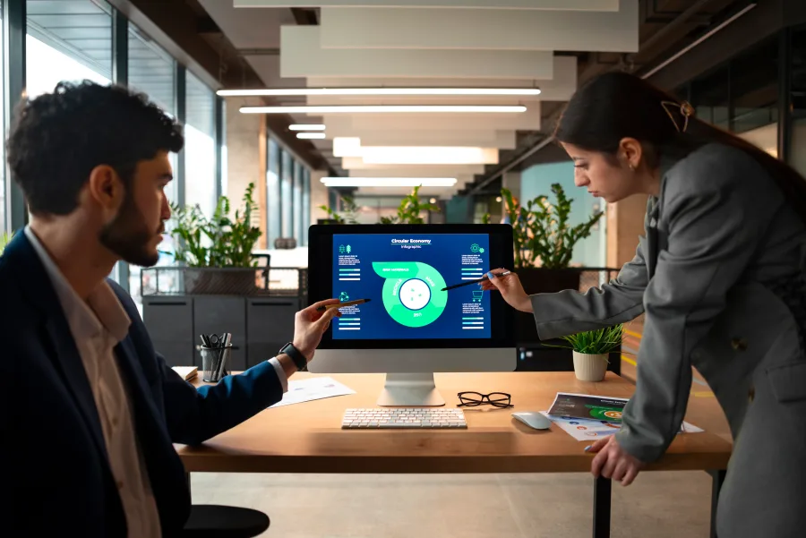 Two colleagues reviewing a SaaS analytics dashboard in an office