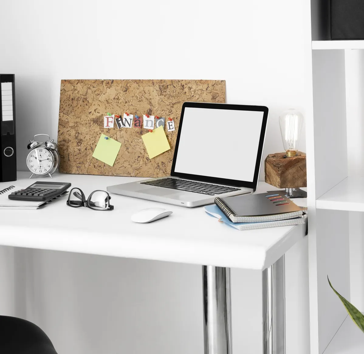 A Voxturr team member’s desk with a laptop, notebooks and a pinboard